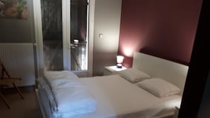 Een net opgemaakt bed met witte lakens in een hotelkamer.
