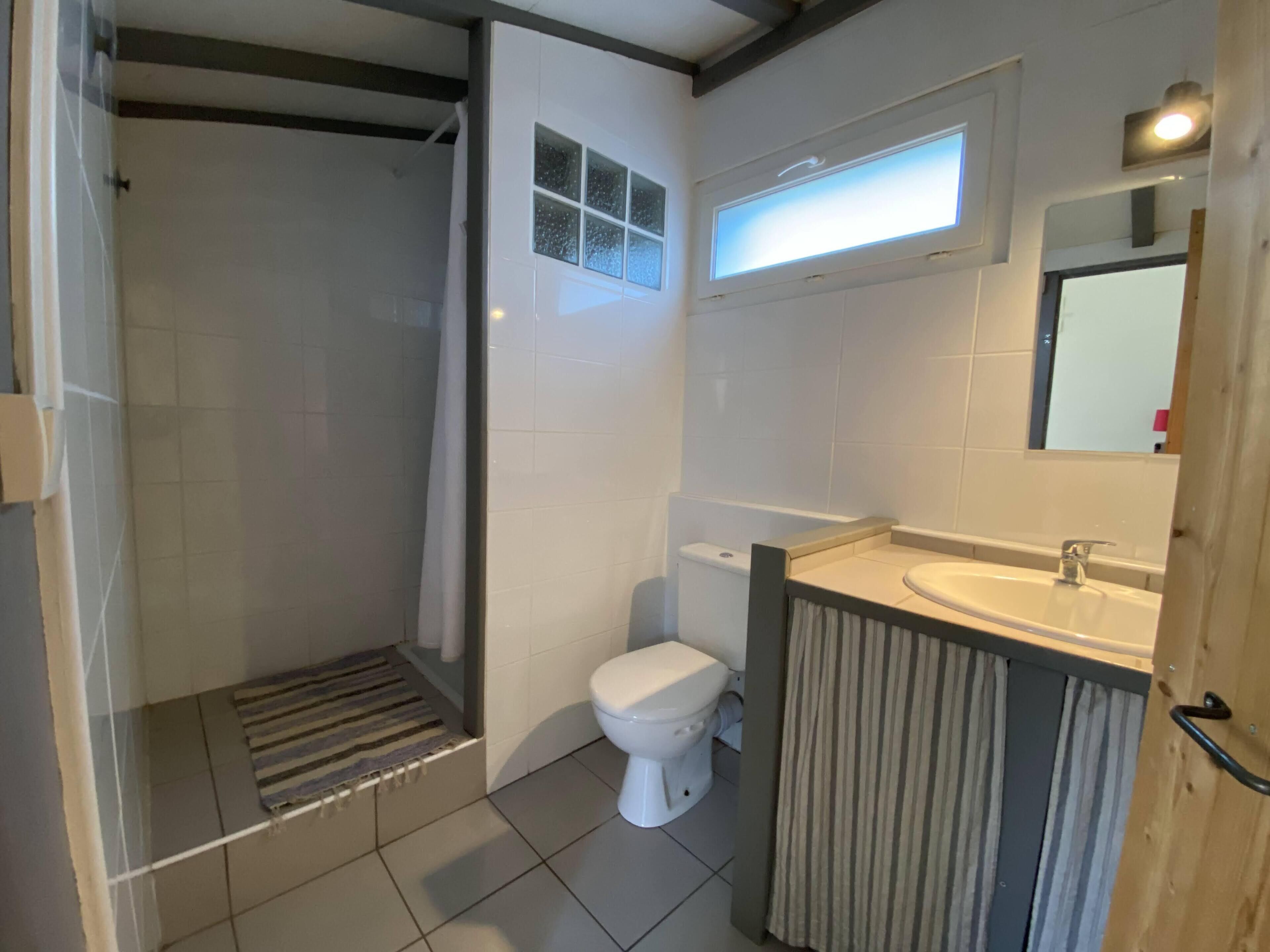 A bathroom with a shower, toilet, and sink.