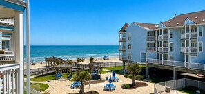 Ein Strandhotel mit Poolbereich, Sitzgelegenheiten im Freien und Blick auf den Ozean.