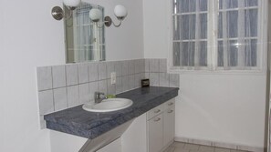 Een bad/douchecombinatie, een haardroger