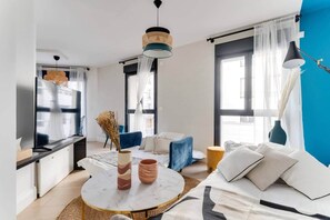 A modern living room with a TV, sofa, coffee table, and decorative items.