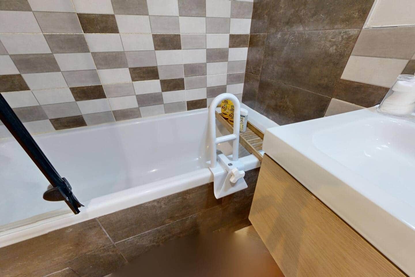 A bathroom with a bathtub, a white sink, and a shower area.