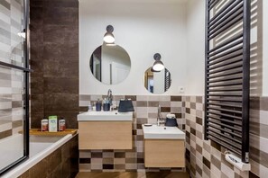 A bathroom with two sinks, a mirror, and a towel rack.