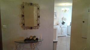 A room with a glass-top table, a white trash bin, and a white chair. - Ground floor villa flat in Monticello (Monticello)