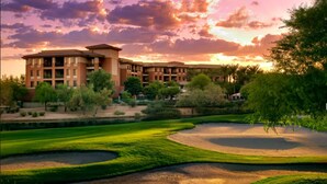 Un campo de golf con búnkeres y un edificio grande al fondo.