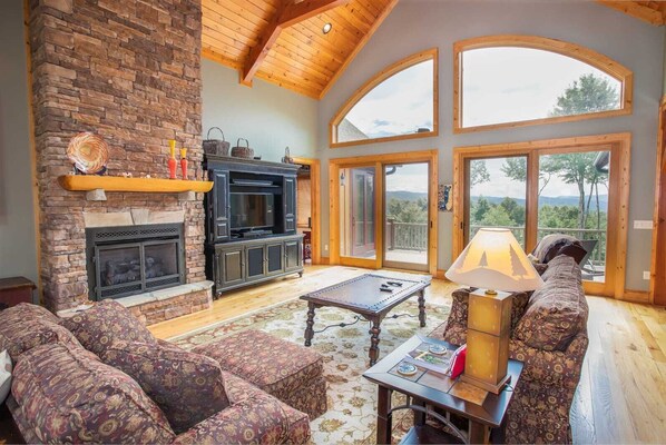 Relax in this inviting living room with a stone fireplace, large window, and comfortable seating area.