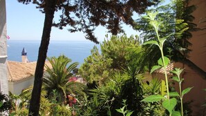 A lush garden with various plants and a view of the sea. - Villa with a stunning sea view, located by the poolside and close to the beach (La Herradura)