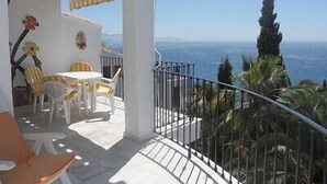 A balcony with a view of the sea, a table with chairs, and a railing. - Villa with a stunning sea view, located by the poolside and close to the beach (La Herradura)