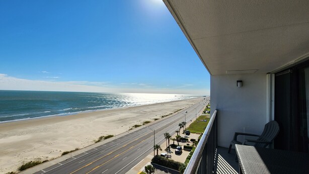 Uma varanda com vista para a praia e oceano.