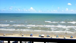 Uma praia com guarda-sóis e pessoas.