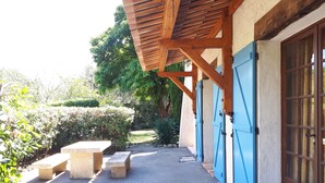 Un espacio al aire libre cubierto con un sendero de grava, bancos y una estructura de pérgola de madera.