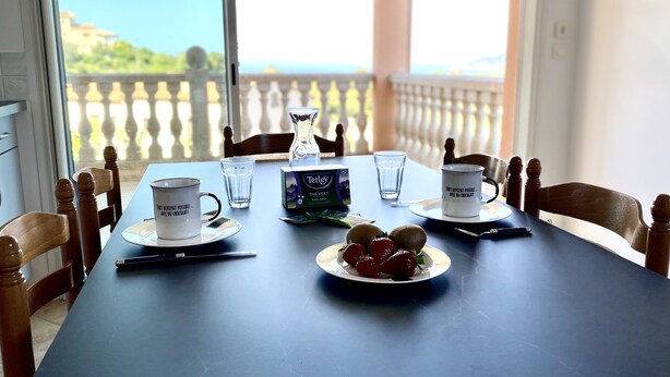 A dining table set with a plate of strawberries, two cups, a vase, and a box of Tetley tea. - Farniente & sunsets on the Gulf of Ajaccio and the Sanguinaires Islands (Bastelicaccia)