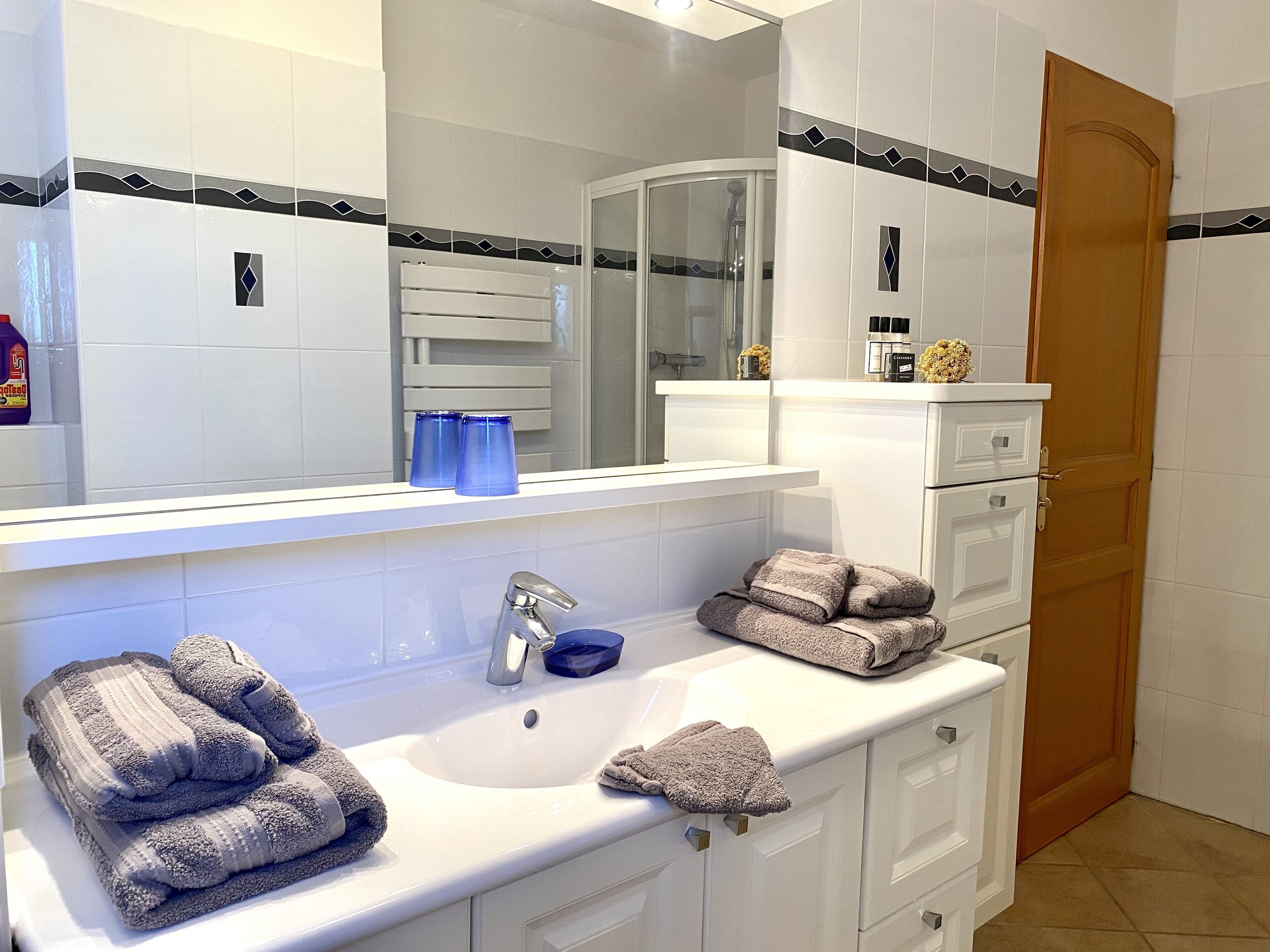 A bathroom with a white sink, a mirror, and a door.