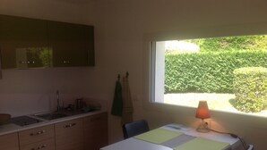 A compact kitchen with a window view of a green garden. - Mimet <season 1/5 to 30/9 >week 630€ or 90€/nuit (Mimet)