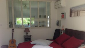 A bedroom with a bed, a guitar, a lamp, a chair, and a bookshelf. - Mimet <season 1/5 to 30/9 >week 630€ or 90€/nuit (Mimet)