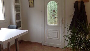 A room with a white door, a window with a view of greenery, a white cabinet, and a plant. - Mimet <season 1/5 to 30/9 >week 630€ or 90€/nuit (Mimet)