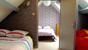 Un dormitorio con cama, armario y papel tapiz estampado.