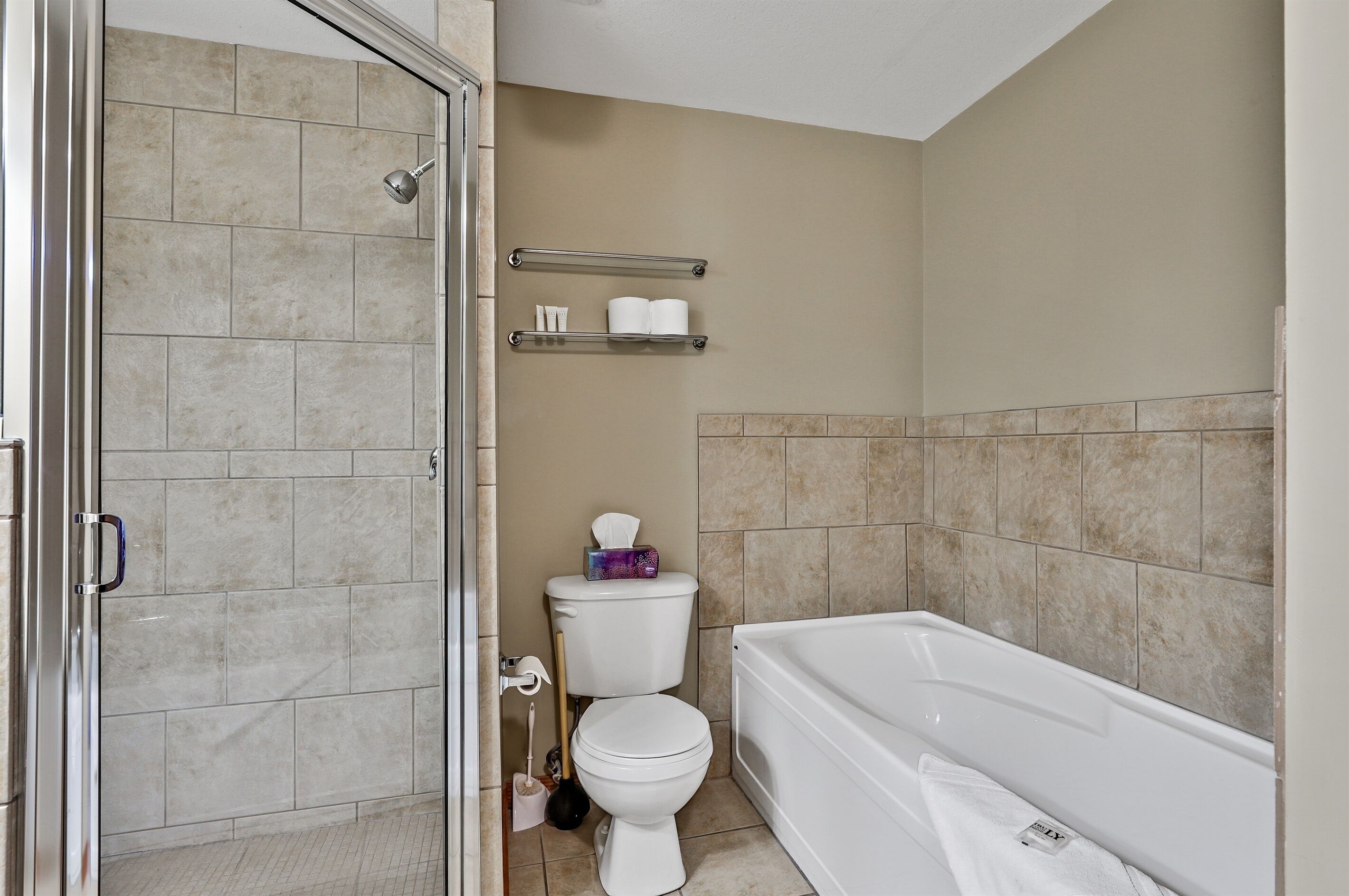 Une salle de bain avec douche, toilettes et baignoire.