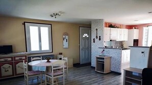 A compact living space with a dining area, kitchenette, and a door leading to another room. - Apartment 1 * "The House of the Artist" (Coulounieix-Chamiers)