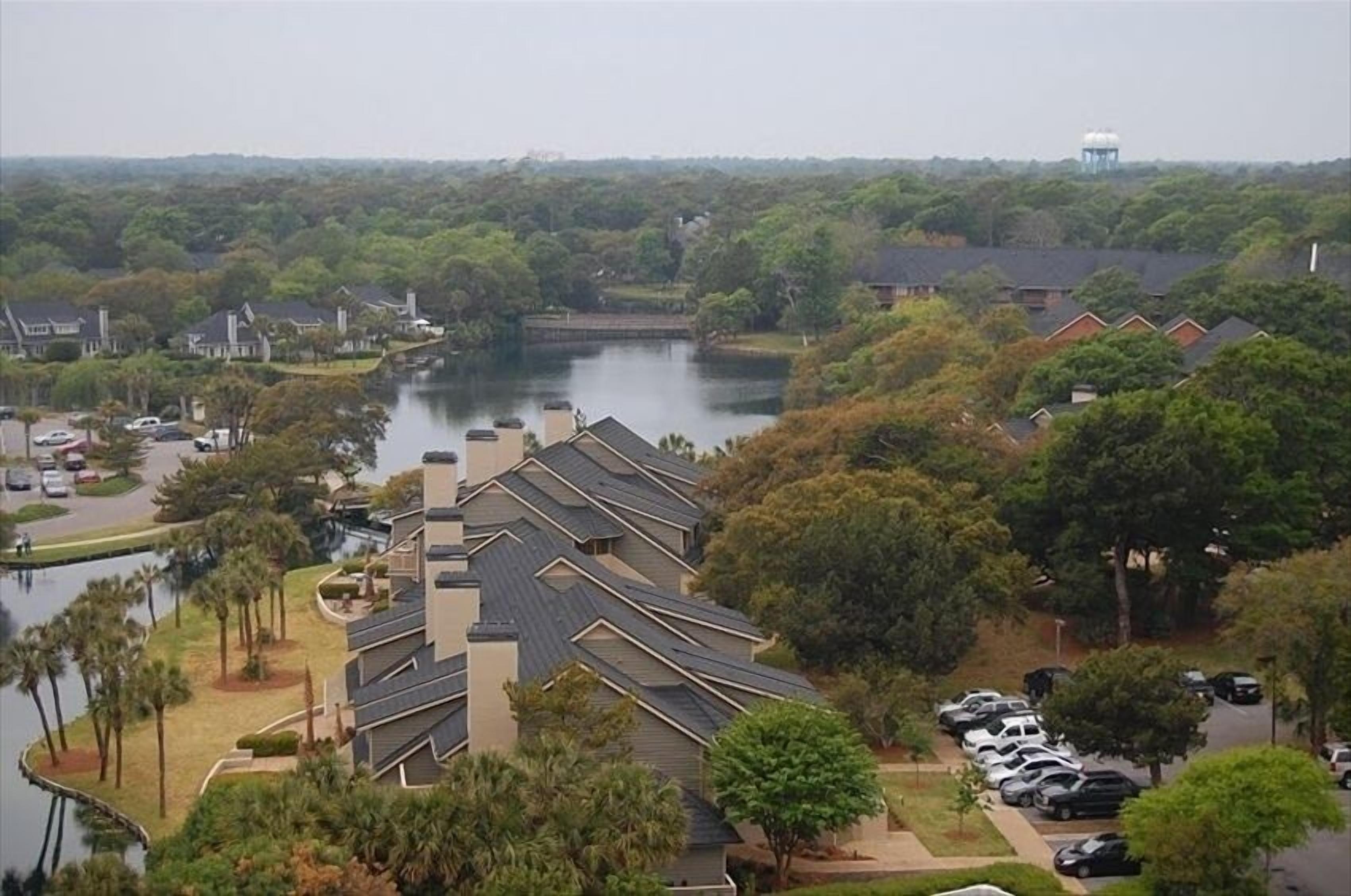 A residential area with houses, a body of water, and a water tower.