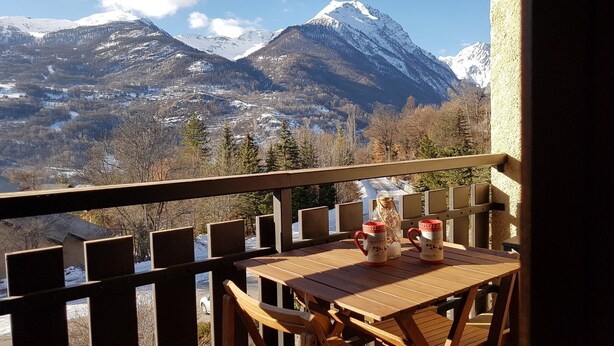A wooden table with two mugs and a glass pitcher on a balcony with a view of snow-capped mountains. - Studio Vallouise, Puy saint vincent, Pelvoux, Les Écrins. Magnificent view (vallouise)