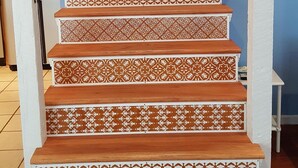 Un escalier avec des marches décorées et un mur bleu.