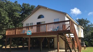 A two-story house with a wooden deck and a covered porch.