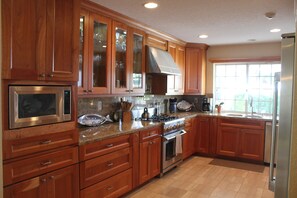 Enjoy cooking in this well-equipped kitchen with stainless steel appliances and a large window offering a view of the outdoors.