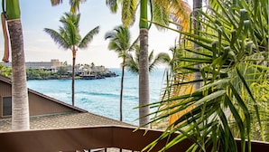 Ein Balkon mit Blick auf das Meer und Palmen.