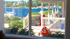 A view from a window overlooking a dock, a gazebo, and a body of water with boats. - Oceanside Retreat  Hubbards Nova Scotia (Hubbards)