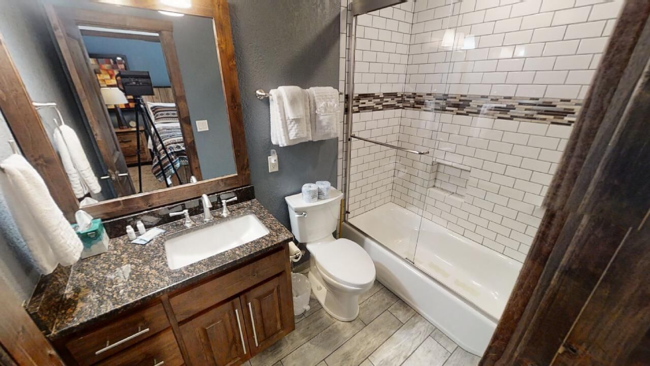 A bathroom with a sink, toilet, and shower area.