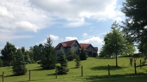 A large house with a red roof, surrounded by a fenced yard and several trees. - Unique home five minutes from Miami University (Oxford)