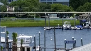 A marina with boats docked, a bridge, and a building in the background.