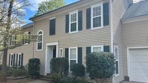 A two-story house with a garage, a front porch, and a driveway.