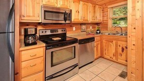 Una cocina con armarios de madera, electrodomésticos de acero inoxidable y una ventana.