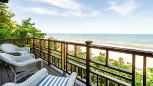 A wooden deck with wicker furniture overlooking a beach. - 2024 remodeled historic Lake Michigan waterfront Union Pier home with spa. (Chikaming Township)
