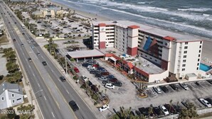 A coastal hotel with multiple floors, a parking lot, and a view of the beach and ocean. - Ocean front w/Balcony -the "How Sweet It Is!" condo with breathtaking Views (Daytona Beach)