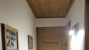 A wooden door with a handle, a light switch, and a small picture frame on the wall to the left. - Apartment ,Direct access to the slopes,4-6 persons,35 m2,beautiful view,wifi (Les Allues)