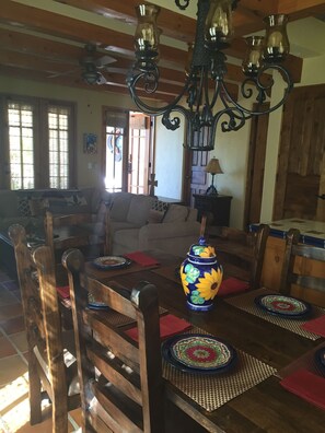 A dining area with wooden chairs, a table with placemats, and a decorative vase.