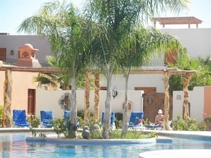 A pool area with lounge chairs, a pergola, and palm trees. - Loreto Bay Villa, 3 BR, 3 Baths, Sleeps Six, 'Casa Maria' (Nopolo)