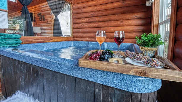 Eine Holzdiele mit Whirlpool, zwei Weingläser, Trauben und Dekorationselementen.