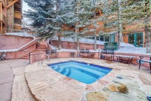 A stone pool with a blue border, surrounded by stone steps and metal railings. - Charming & upscale Condo in the Heart of Aspen (Aspen)