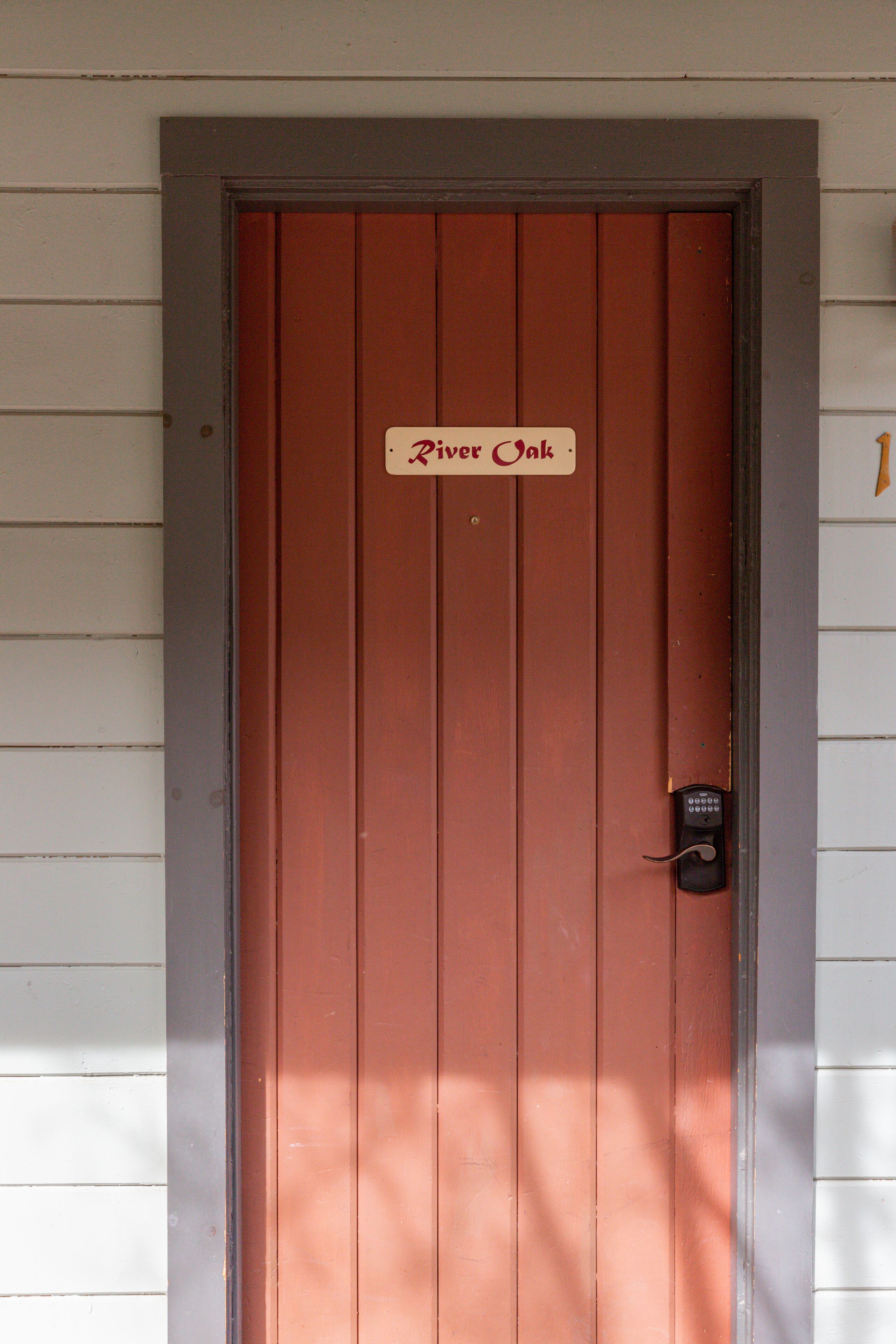 A brown door with a sign that reads "River Oak."
