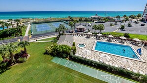 Ein Resort mit großem Pool, Tennisplätzen und Blick auf den Ozean.