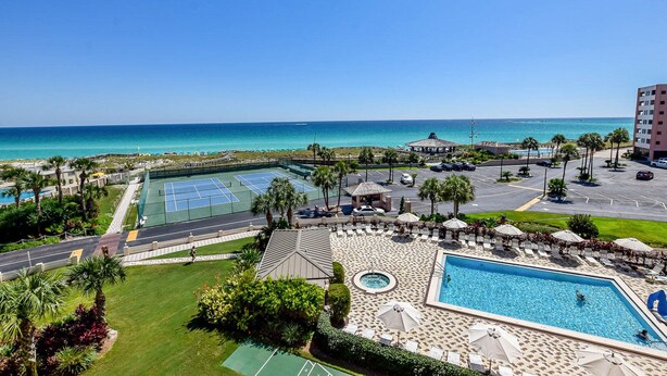 Ein Resort mit Schwimmbad, Tennisplätzen und Meerblick.