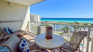 Ein Balkon mit Blick auf das Meer, einem runden Tisch und zwei Stühlen.