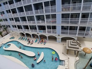 A multi-level hotel with a pool area featuring slides, lounge chairs, and a water slide. - MBV 4Br/3Ba - 301B (Myrtle Beach)