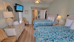 A hotel room with two beds, a television, a mirror, and a door leading to a bathroom. - MBV 4Br/3Ba - 301B (Myrtle Beach)
