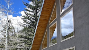A modern building with large windows and a wooden deck. - Beautiful Mountain Retreat Just Minutes From the Slopes!! (Taos Ski Valley)