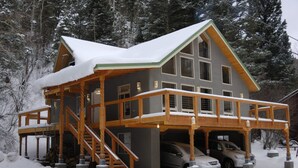 A two-story house with a covered porch and a carport. - Beautiful Mountain Retreat Just Minutes From the Slopes!! (Taos Ski Valley)